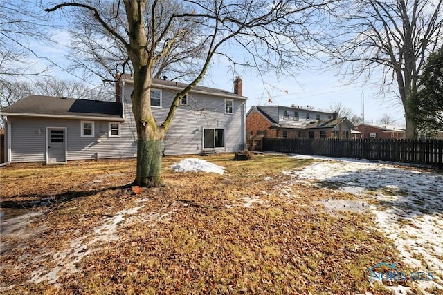 rear view of property with fence and a chimney