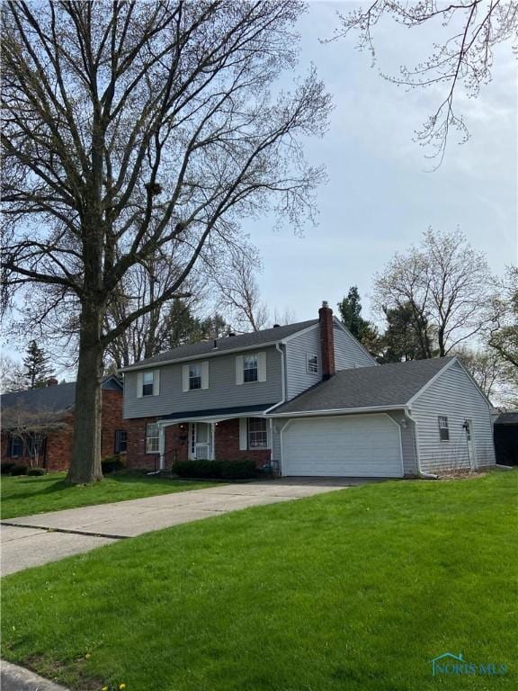 view of front of property featuring an attached garage, driveway, a chimney, and a front lawn