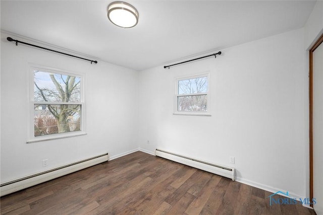 unfurnished room featuring baseboards, a baseboard heating unit, baseboard heating, and wood finished floors