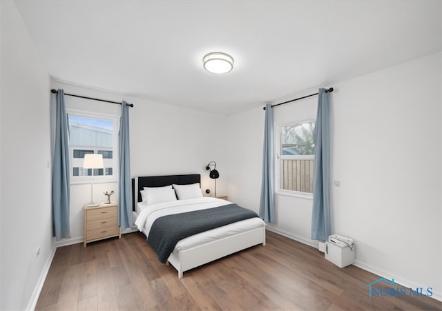 bedroom featuring wood finished floors and baseboards