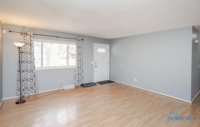 foyer with baseboards and wood finished floors