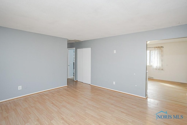 empty room with baseboards and wood finished floors