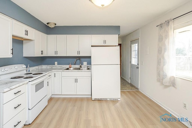 kitchen with light wood-type flooring, light countertops, white appliances, white cabinetry, and a sink