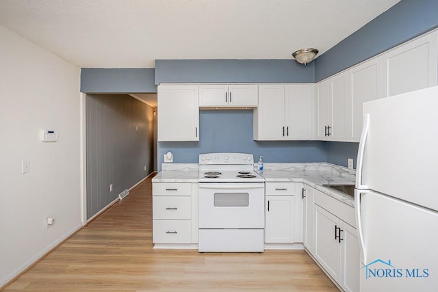 kitchen with light wood-type flooring, light stone counters, white appliances, white cabinetry, and a sink