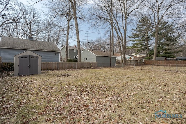 view of yard featuring an outdoor structure, fence, and a shed