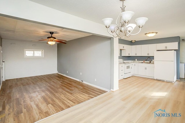 kitchen featuring electric range, light wood-style flooring, a sink, freestanding refrigerator, and light countertops