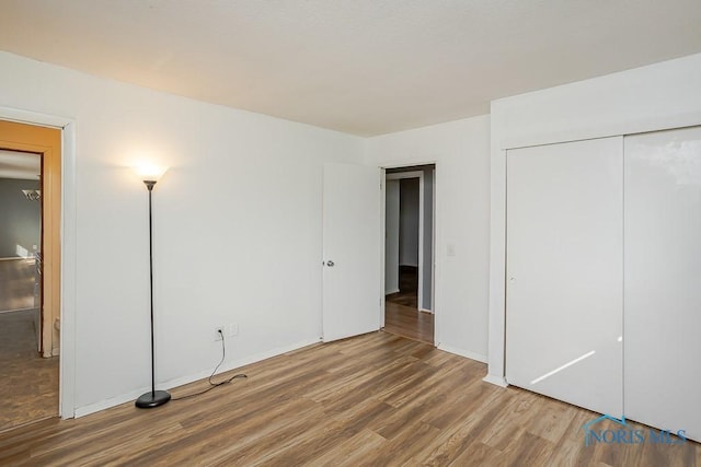 unfurnished bedroom featuring wood finished floors and a closet