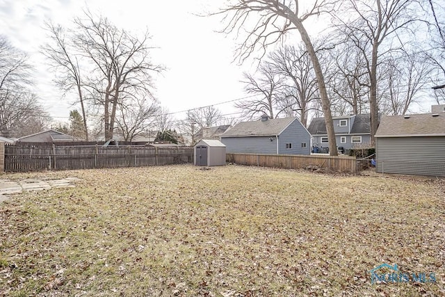 view of yard with an outbuilding, a storage shed, and a fenced backyard