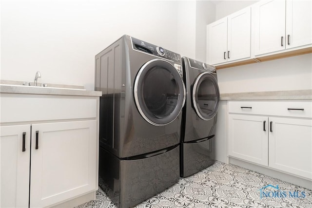 laundry room with washer and dryer, cabinet space, and light tile patterned floors