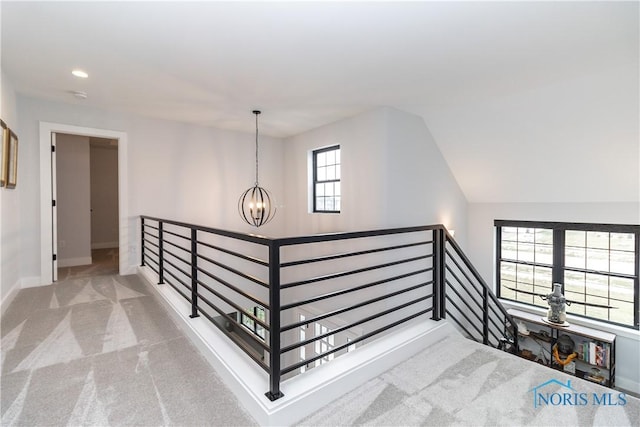 hallway featuring carpet, recessed lighting, an inviting chandelier, an upstairs landing, and baseboards