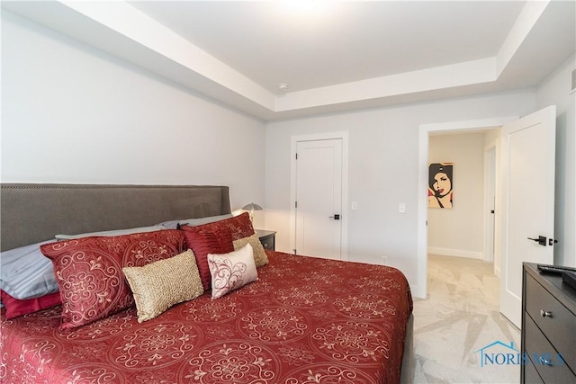 bedroom with baseboards, a tray ceiling, and light colored carpet