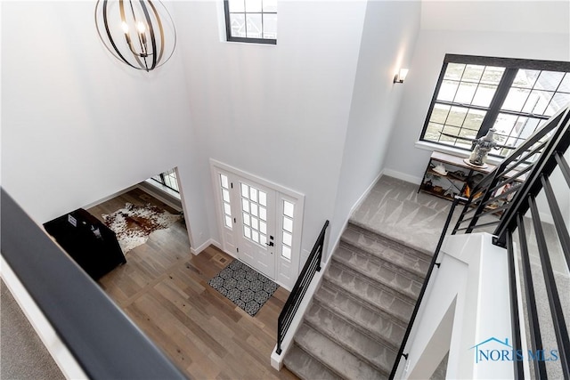 foyer entrance with stairs, baseboards, and wood finished floors