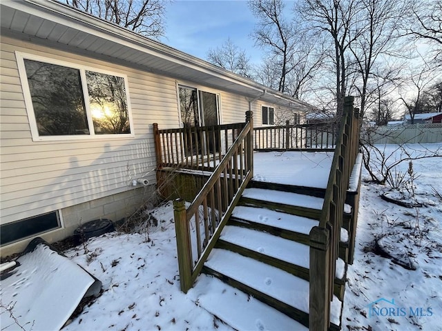 snow covered deck featuring stairs