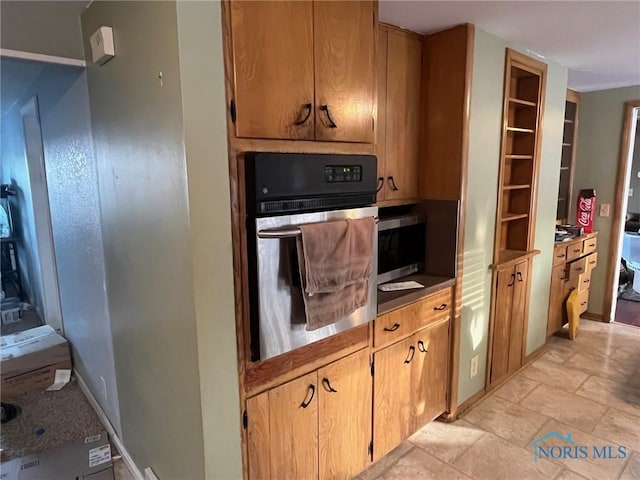 kitchen featuring stainless steel appliances, stone finish floor, and baseboards