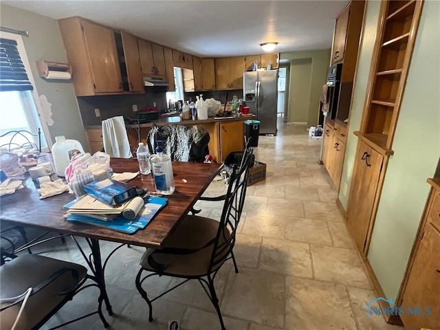 dining room featuring stone tile flooring and a wealth of natural light