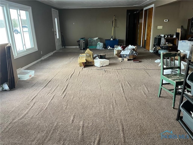 carpeted living area with baseboards