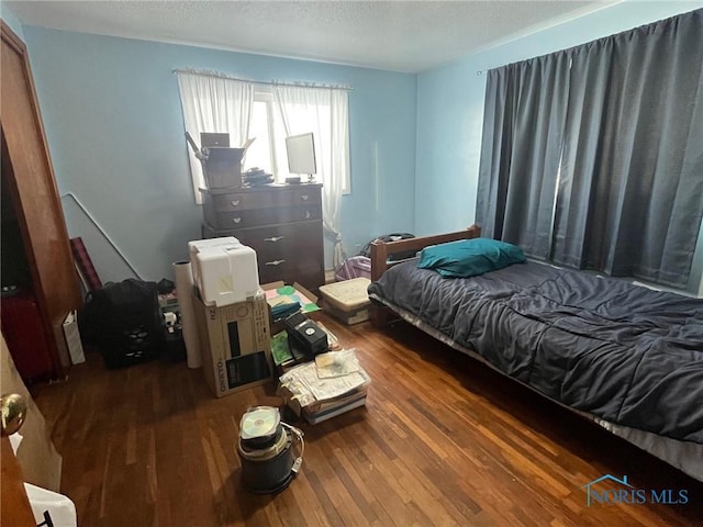 bedroom featuring a textured ceiling and wood finished floors