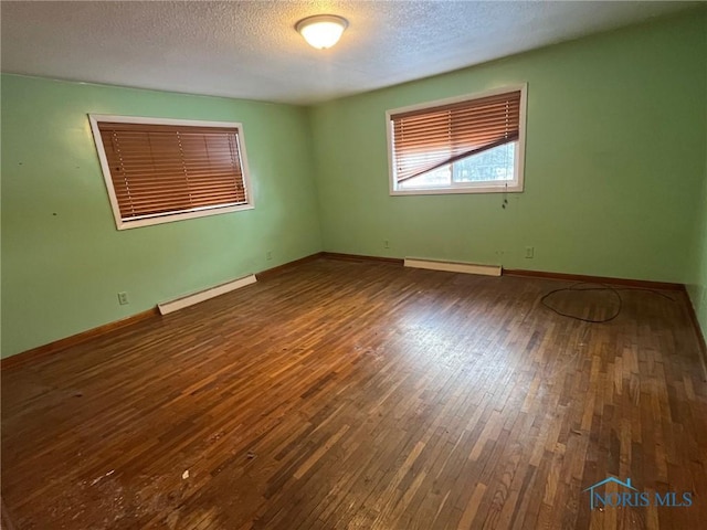 unfurnished room with a baseboard radiator, baseboards, a textured ceiling, and hardwood / wood-style floors