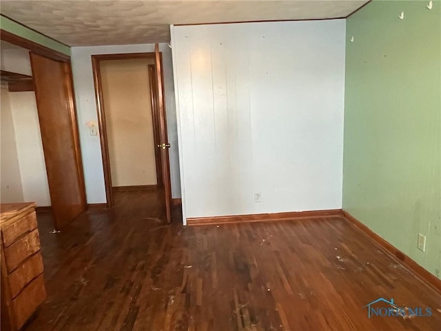 unfurnished room with wood finished floors and baseboards