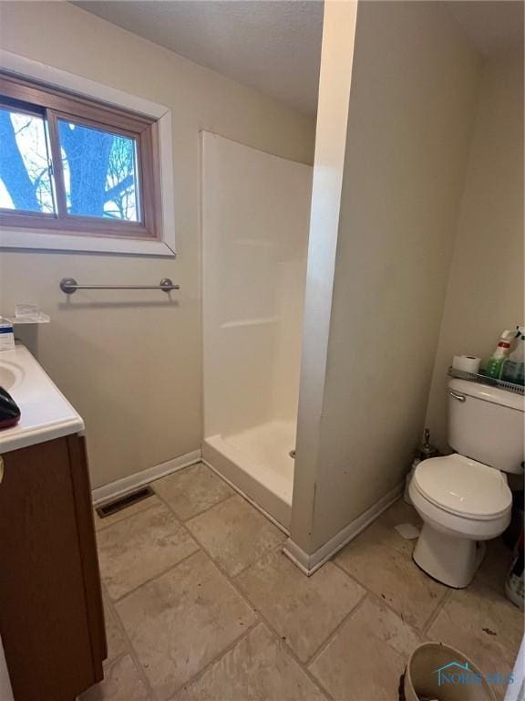 full bath featuring visible vents, toilet, a stall shower, vanity, and baseboards