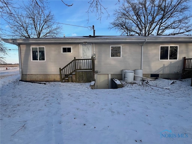 snow covered house featuring a garage