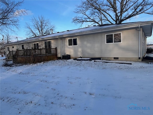 snow covered back of property featuring a wooden deck and central AC unit