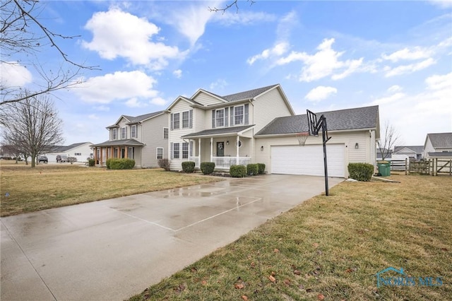 traditional-style home featuring a garage, covered porch, concrete driveway, and a front yard