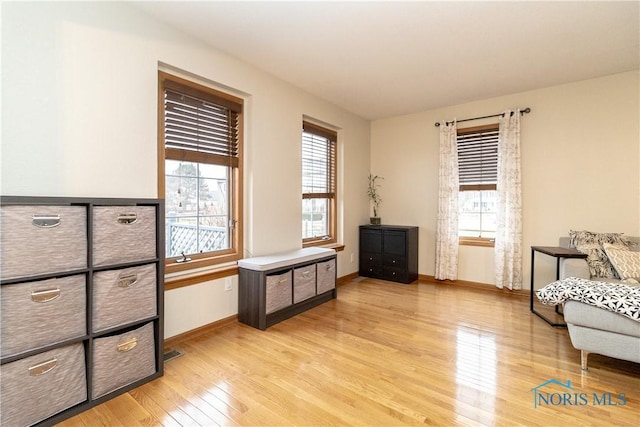 living area featuring light wood-type flooring, baseboards, and visible vents