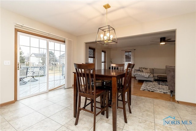 dining space featuring light tile patterned floors, baseboards, and an inviting chandelier