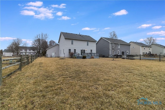 back of house with fence, a lawn, and a residential view