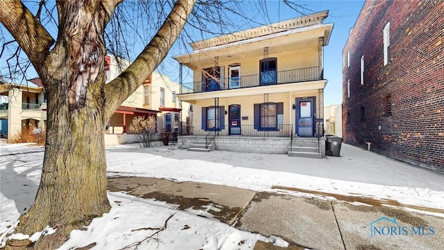 view of front of property featuring a porch and a balcony