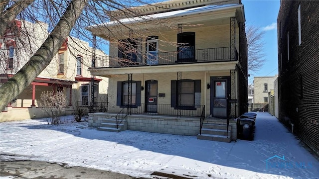 view of front facade featuring covered porch and a balcony