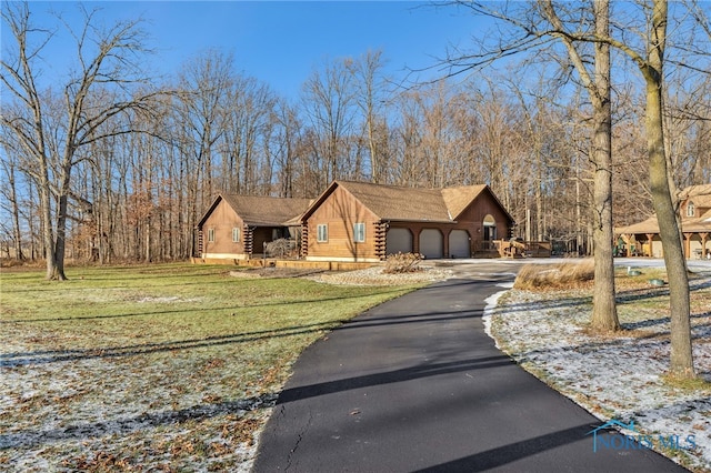 log home with a garage, log exterior, and a front lawn