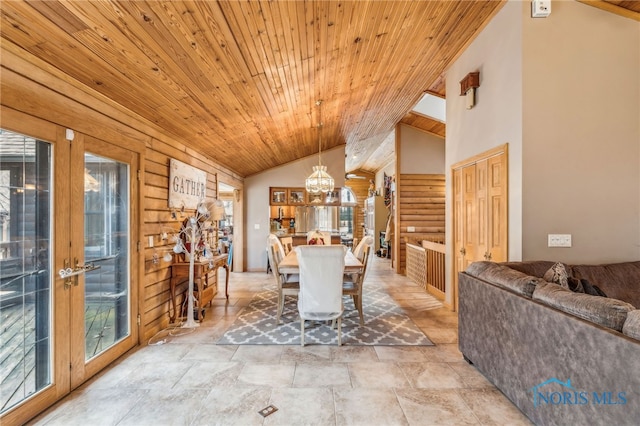 dining space featuring log walls, lofted ceiling, wood ceiling, stone finish floor, and a chandelier