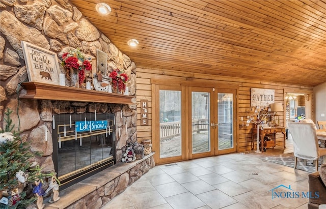 living room featuring vaulted ceiling, wood ceiling, a fireplace, and french doors