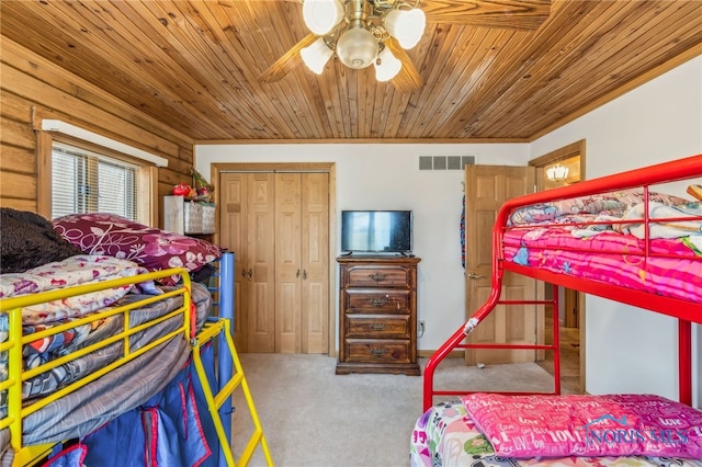 carpeted bedroom with wood ceiling, ceiling fan, a closet, and visible vents