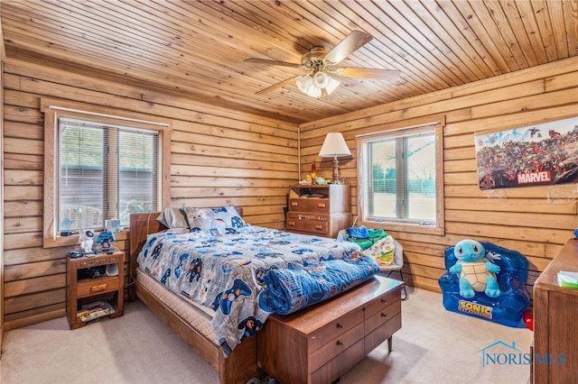 carpeted bedroom with wood ceiling, ceiling fan, and wood walls