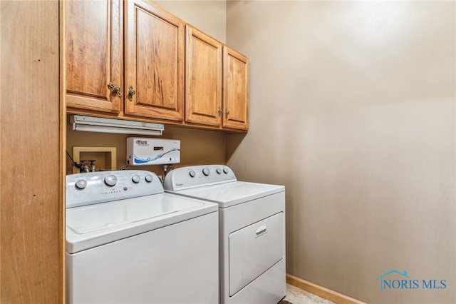 laundry area with washing machine and clothes dryer, cabinet space, and baseboards