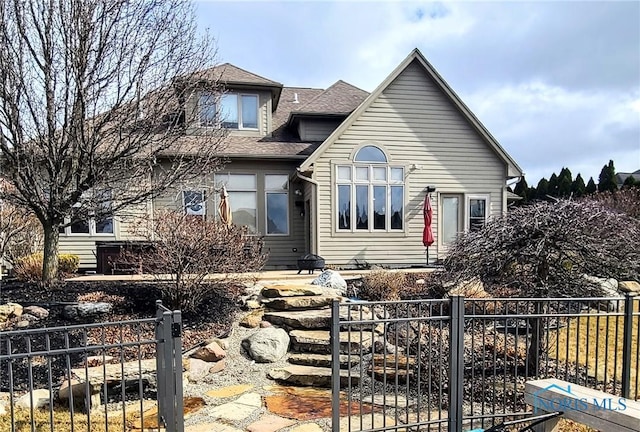 view of front facade featuring a fenced front yard and roof with shingles