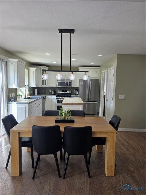 dining room featuring dark wood-style floors, baseboards, and recessed lighting