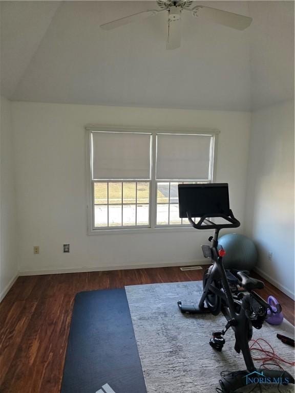 exercise room featuring vaulted ceiling, ceiling fan, dark wood-style flooring, and baseboards