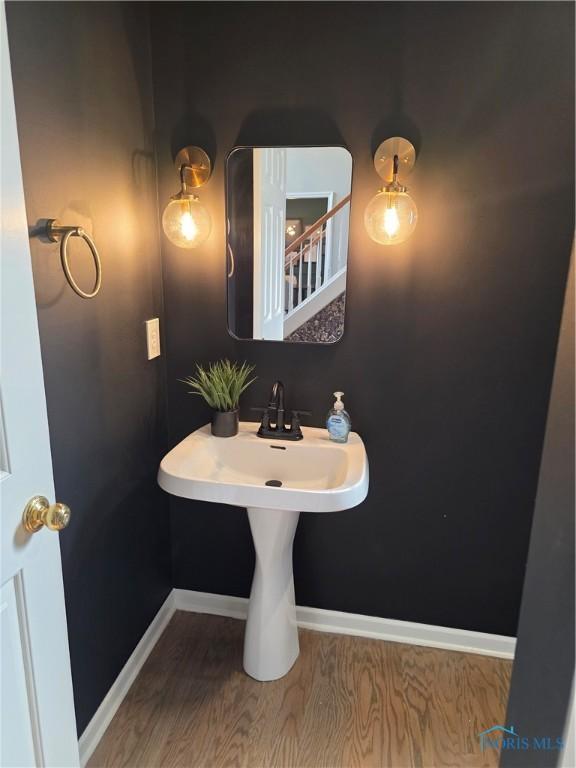 bathroom with wood finished floors and baseboards