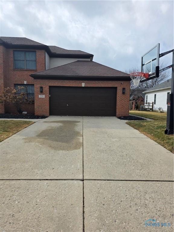 view of front of home featuring driveway, brick siding, an attached garage, and a shingled roof