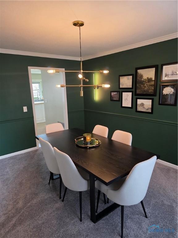 carpeted dining room with baseboards and ornamental molding