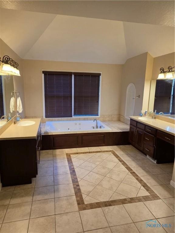 bathroom featuring lofted ceiling, a garden tub, a sink, and tile patterned floors