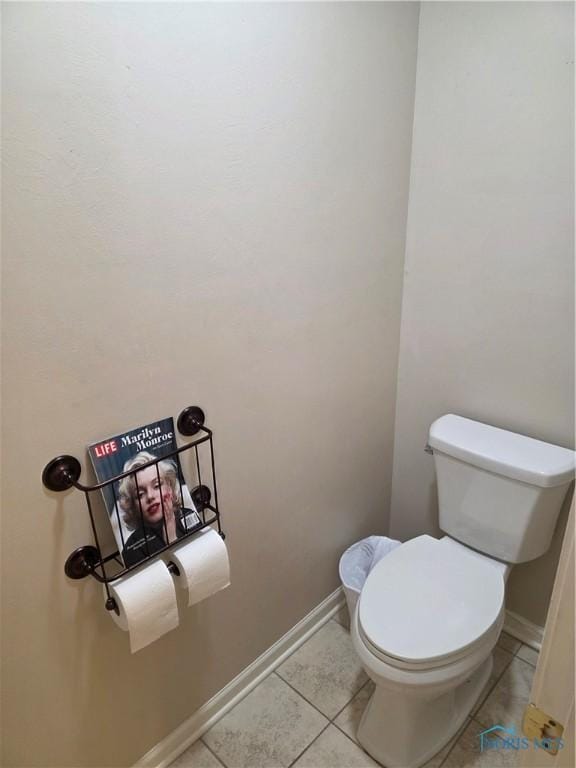 bathroom featuring tile patterned flooring, baseboards, and toilet