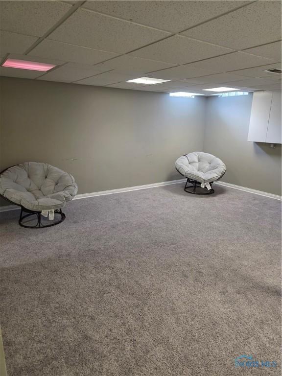 unfurnished room featuring carpet floors, baseboards, and a paneled ceiling