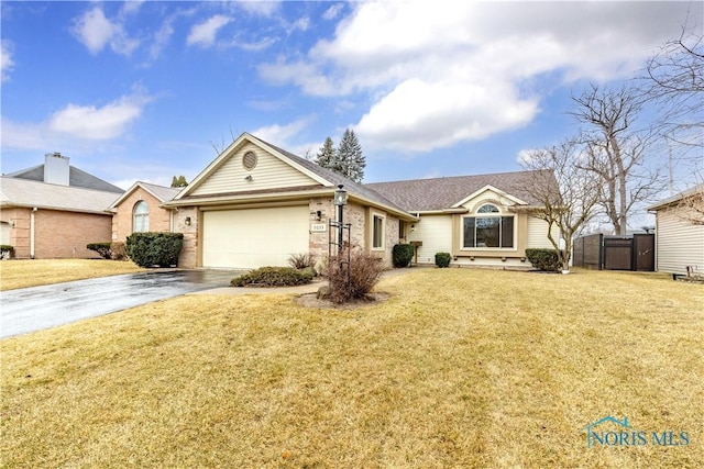 single story home with an attached garage, fence, driveway, a gate, and a front yard