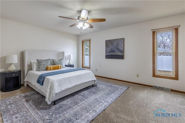 carpeted bedroom featuring baseboards, visible vents, and ceiling fan