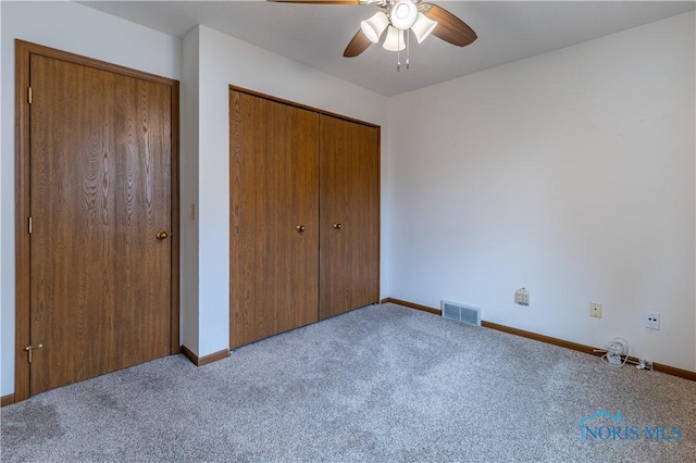 unfurnished bedroom with carpet floors, a ceiling fan, visible vents, baseboards, and a closet